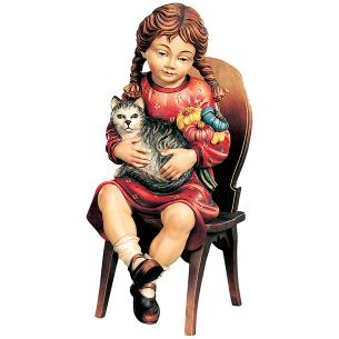 Ragazza seduta con gattino e fiori su sedia